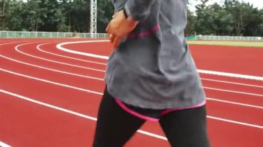 Stadyum pistinde spor kıyafetleriyle koşan atletik bir kadın. Kadın koşucu egzersiz için koşuyor. Spor Sağlıklı yaşam tarzı konsepti.