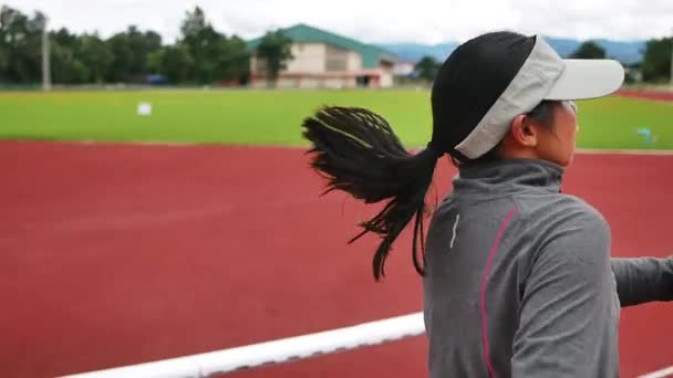 累了的女赛跑选手在体育场的跑道上跑得很辛苦 休息一下 健康生活方式的概念 — 图库视频影像