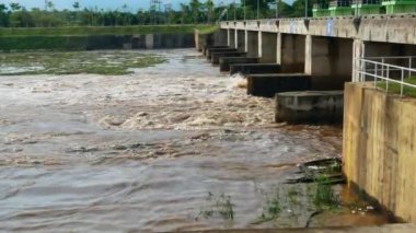 Barajdan su akması. Düşük barajdan akan su manzarası güçlü akıntıyla birlikte. Kaygan taşlar ve beyaz köpük oluşumu. Hidroelektrik santrali.