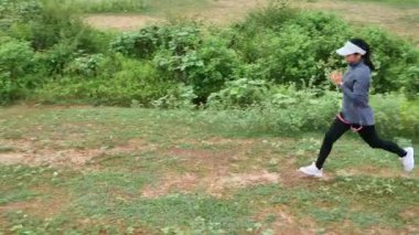 Orman yolunda koşan atletik bir kadın. Sabahları doğada koşan kadın koşucular. Spor Sağlıklı yaşam tarzı konsepti.