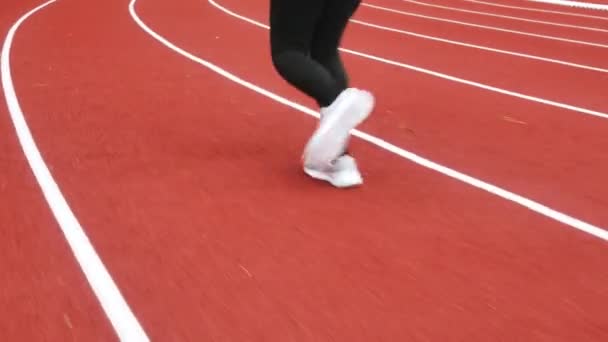 身穿运动服的女运动员在体育场跑道上跑步 女赛跑选手慢跑锻炼身体 健康生活方式的概念 — 图库视频影像