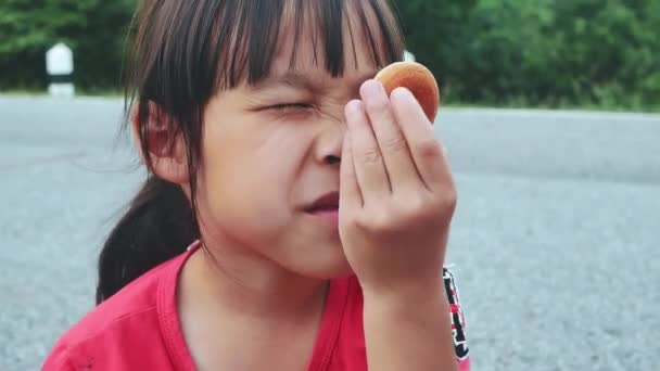 Χαριτωμένο Κοριτσάκι Που Τρώει Μικρά Ντόνατς Στο Πάρκο Παιδί Διασκεδάζει — Αρχείο Βίντεο