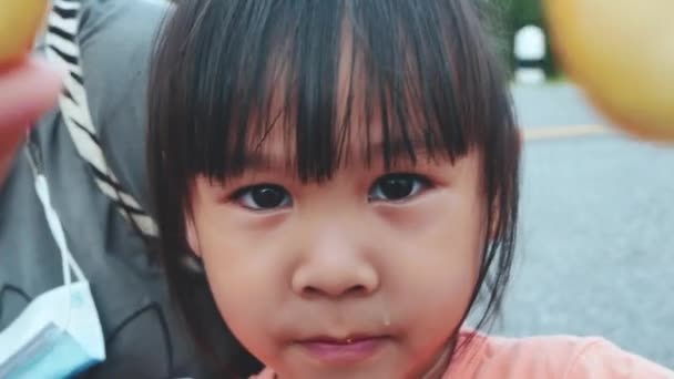 可爱的小女孩在公园里吃着小甜甜圈 孩子们在和甜甜圈玩乐 糖与糖的概念 — 图库视频影像