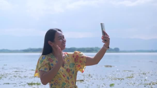 아시아 관광객들은 기분좋게 친구와 비디오 통화를 스마트폰을 사용하고 자연의 — 비디오