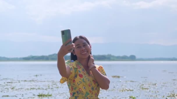 아시아 관광객들은 스마트폰을 사용하여 날에도 즐거운 기분으로 경치를 감상하고 자연의 — 비디오