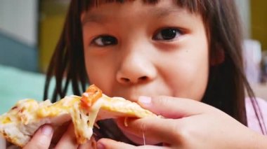 Pizza yiyen tatlı küçük kızlar. Evde pizza partisinde pizza yiyen aç bir çocuk. Aile tatili kavramı.