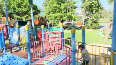 Aktif küçük kız parkın bahçesinde eğleniyor. Küçük şirin bir kız çocuk parkına tırmanıp kayıyor. Oyun çocuklukta öğrenmektir..