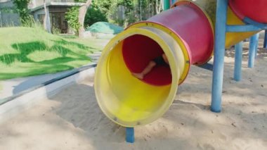 Dışarıdaki oyun alanında renkli kaydırak üzerinde oynayan aktif küçük kız kardeşler. Çocuk parkında gülümseyen ve gülen mutlu kız çocukları. Oyun çocuklukta öğrenmektir..