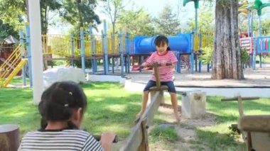 Dışarıdaki parkta tahterevallide oynayan aktif küçük kız kardeşler. Çocuk parkında gülümseyen ve gülen mutlu kız çocukları. Oyun çocuklukta öğrenmektir..