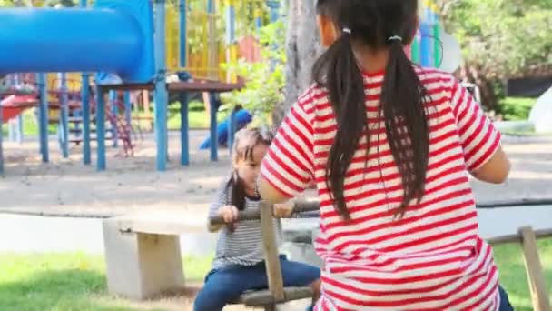 Активные Маленькие Сёстры Играют Качелях Открытой Площадке Счастливые Девочки Улыбаются — стоковое видео