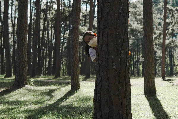 Maskeli Bir Kadın Parktaki Ağacın Arkasından Dışarı Bakıyor Bir Yaz — Stok fotoğraf