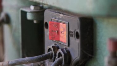 Atölyedeki bir sondaj makinesinin açma kapama düğmesine yakın çekim.