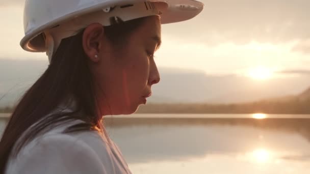 女工程师勘察大坝建筑工地以发电 头戴白色头盔的自信的女建筑师看着大坝建筑工地 清洁能源和技术概念 — 图库视频影像
