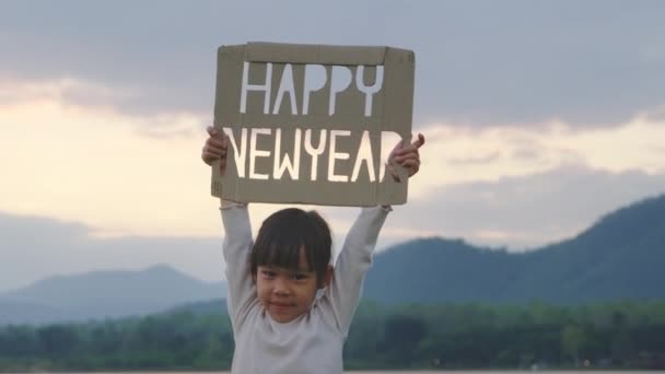Little Girl Holding Happy New Year Design Cardboard Background Mountains — Stockvideo