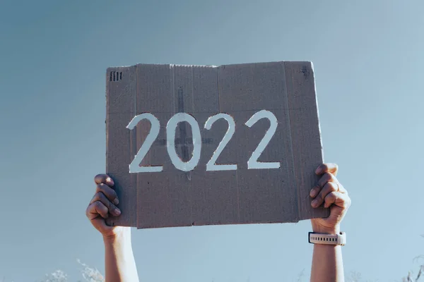 Hands Holding New Year 2022 Design Cardboard Background Blue Sky — Stock Photo, Image