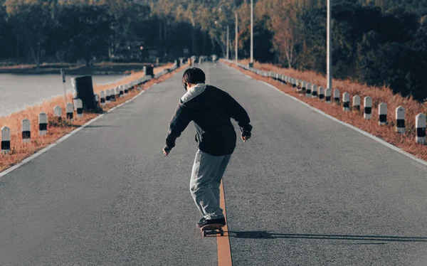 Skateboarder Patinaje Una Carretera Junto Lago Atardecer Joven Patinador Niño —  Fotos de Stock