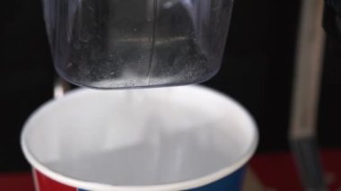 Hands pressing ice from ice machine for refill self service in Kentucky Fried Chicken or KFC fast food restaurant in thailand.