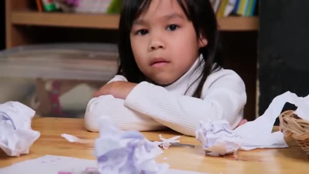 家でカラフルな絵を描いている少女を動揺させ 机の上の紙を砕いた コロナウイルスのパンデミックの間にオンライン学習と宿題に退屈している女の子 — ストック動画