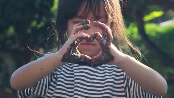 Χαριτωμένο Κοριτσάκι Λασπωμένα Χέρια Κάνει Ένα Σχήμα Καρδιάς Χέρια Της — Αρχείο Βίντεο