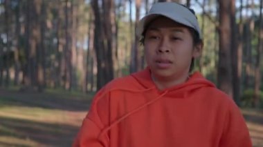 Yorgun kadın koşucu, sabah antrenmanında orman yolunda koştuktan sonra dinleniyor. Sağlıklı yaşam tarzı kavramı. Sporcu dışarıda egzersiz yapıyor..