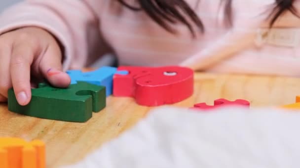 かわいい少女パジャマを着て自宅でジグソーパズルを演奏 子供のための楽しい教育活動 — ストック動画