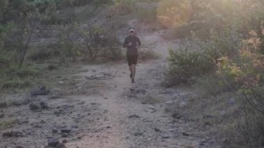 Sağlıklı genç çocuklar egzersiz yapmak için orman yolunda koşarlar. Genç erkek sporcu dışarıda koşuyor. sağlıklı yaşam tarzı kavramı