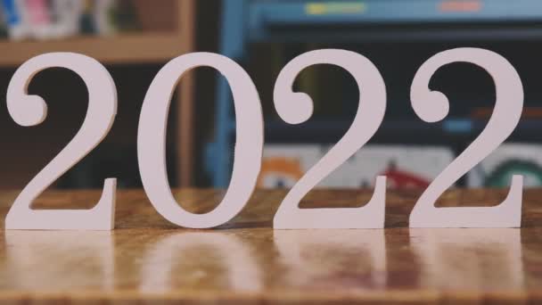 2022年的白色数字被放置在房子的木制桌子上 新的一年2022 — 图库视频影像