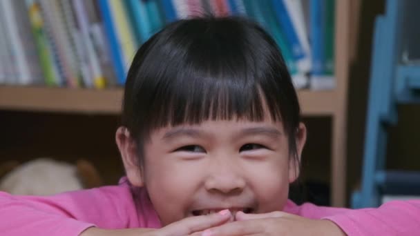 Портрет Смешной Маленькой Девочки Улыбающейся Смотрящей Камеру Сидящую Дома Диване — стоковое видео