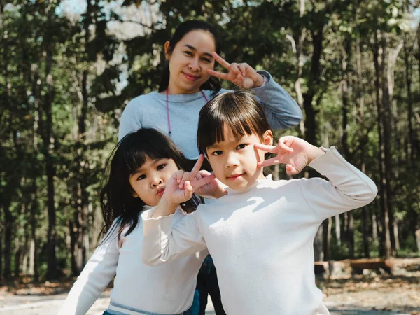 2人の可愛いアジア系の女の子が夏服を着ていて 美しい若い母親と楽しい時間を過ごしています 母親と家族の概念 — ストック写真