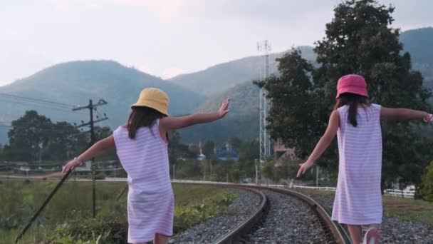 Δύο Χαριτωμένες Ασιάτισσες Που Ισορροπούν Στις Γραμμές Του Τρένου Χέρια — Αρχείο Βίντεο
