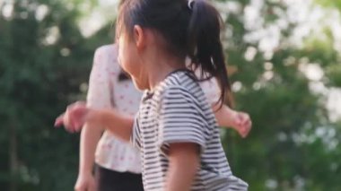 Anne ve çocuklar parkta birlikte oynuyorlar. Mutlu aile tatilde birlikte aktiviteler yapıyor..