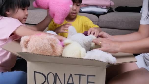 两个可爱的姐姐和她的母亲把她的衣服放进了捐款箱 在家里帮助穷人 捐赠概念 — 图库视频影像