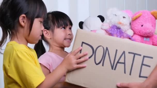 Jonge Vrouw Vrijwilliger Geeft Een Donatie Doos Met Veel Poppen — Stockvideo