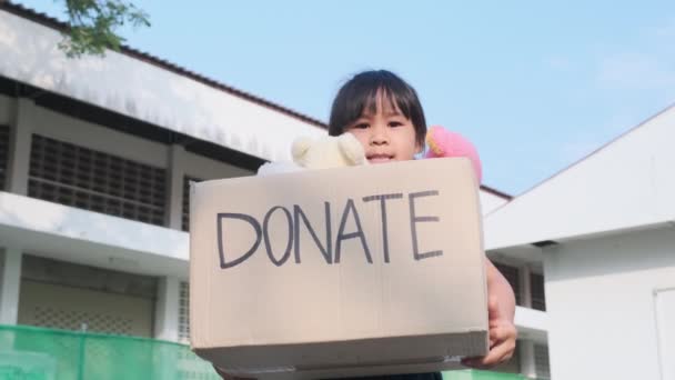 Милая Маленькая Девочка Держит Коробку Пожертвований Старыми Куклами Улице Концепция — стоковое видео