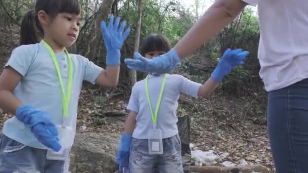 アジアのボランティア家族のグループは 川のゴミを拾う前に手を合わせました 環境を救うためにゴミ箱にゴミを入れてください 世界環境デー — ストック動画