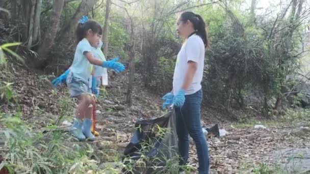 幸せな母親と子供たちは 川でゴミを拾い上げた後 成功した5を作ります 環境を救うためにゴミ箱にゴミを入れてください 世界環境デー — ストック動画