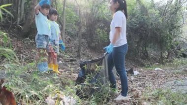 Mutlu anne ve çocuklar nehir kenarındaki çöpleri topladıktan sonra başarılı bir beşlik çakıyorlar. Çevreyi kurtarmak için çöpü çöpe atın. Dünya Çevre Günü