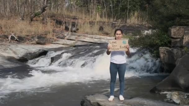 Portret Kobiety Stojącej Miłością Plakat Twojej Matki Ziemi Nad Wodospadem — Wideo stockowe