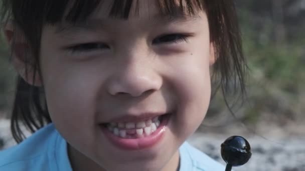 Милая Маленькая Девочка Ест Леденцы Счастливая Маленькая Азиатская Девочка Любит — стоковое видео