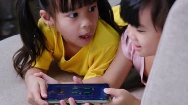 İki kız kardeş akıllı telefon için kavga ediyor. Birbirlerinden agresif duygularla alet alıyorlar. Modern iletişim ve cihaz bağımlılığı kavramı.