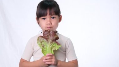 Çocuklar sebze yemeyi sevmez. Yeşil salata yemekten nefret eden küçük kız..