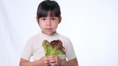 Çocuklar sebze yemeyi sevmez. Yeşil salata yemekten nefret eden küçük kız..