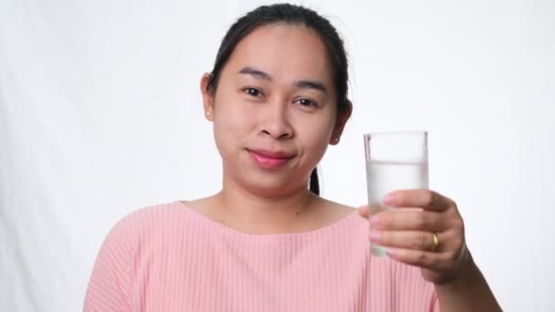 Усміхнена Жінка Тримає Склянку Води Великі Пальці Білому Тлі Студії — стокове відео
