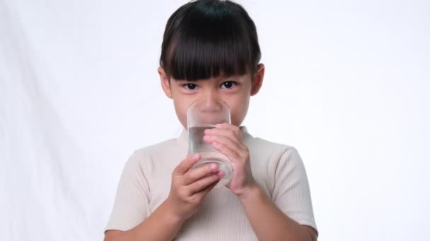 Carino Piccola Ragazza Asiatica Bere Acqua Bicchiere Sfondo Bianco Studio — Video Stock