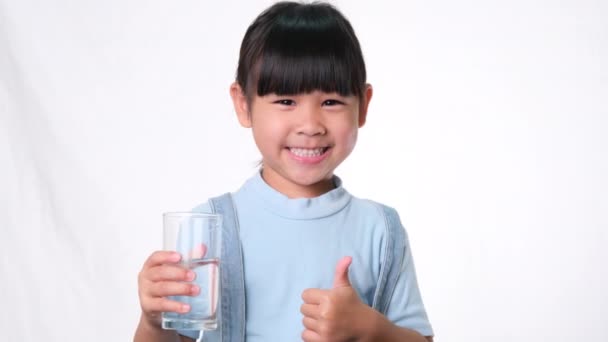Bonito Pouco Ásia Menina Segurando Copo Água Mostrando Polegares Para — Vídeo de Stock