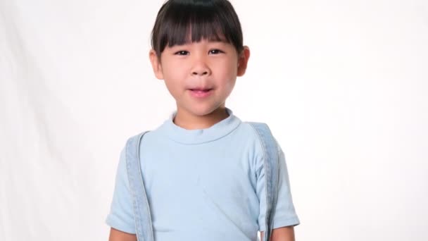 Mutlu Küçük Kız Gülümsüyor Stüdyoda Beyaz Arka Planda Parmağını Gösteriyor — Stok video