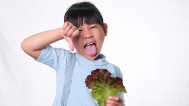 Çocuklar sebze yemeyi sevmez. Yeşil salata yemekten nefret eden küçük kız..