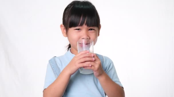Asiática Niña Linda Bebiendo Leche Vaso Sonrisa Sobre Fondo Blanco — Vídeo de stock