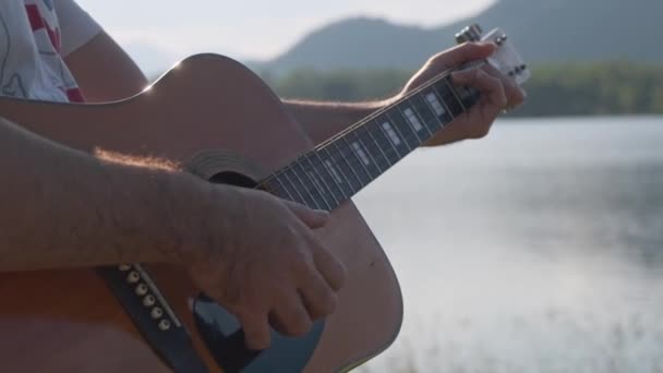 Bonito Encaracolado Asiático Homem Tocando Guitarra Cantando Junto Lago Pôr — Vídeo de Stock