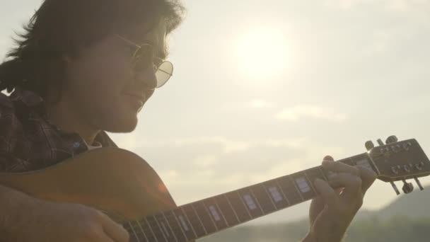 Przystojny Kręcone Włosy Azjata Gra Gitarze Śpiewa Nad Jeziorem Zachodzie — Wideo stockowe